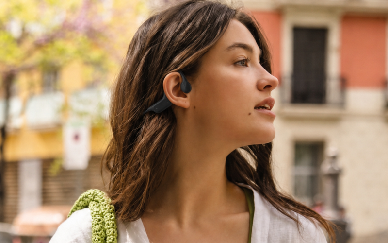 Mujer joven con audifonos open-ear OSSonic