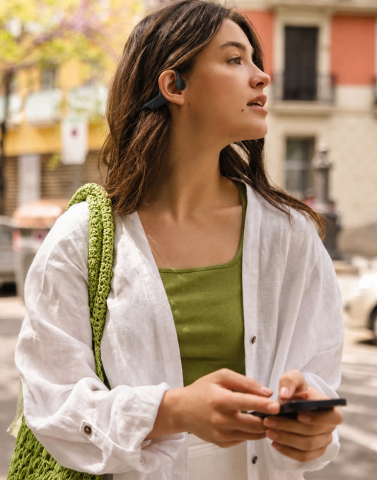 Mujer joven con audifonos open-ear OSSonic